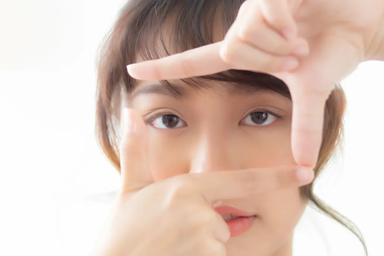 Woman framing her eyes to emphasise her double eyelids
