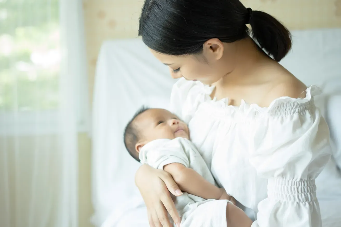 Woman holding and looking at her baby.