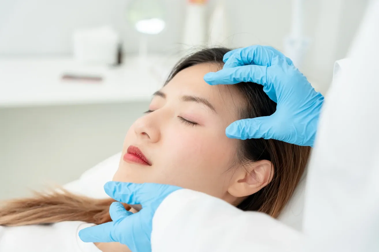 Plastic surgeon examining the eye area of a patient