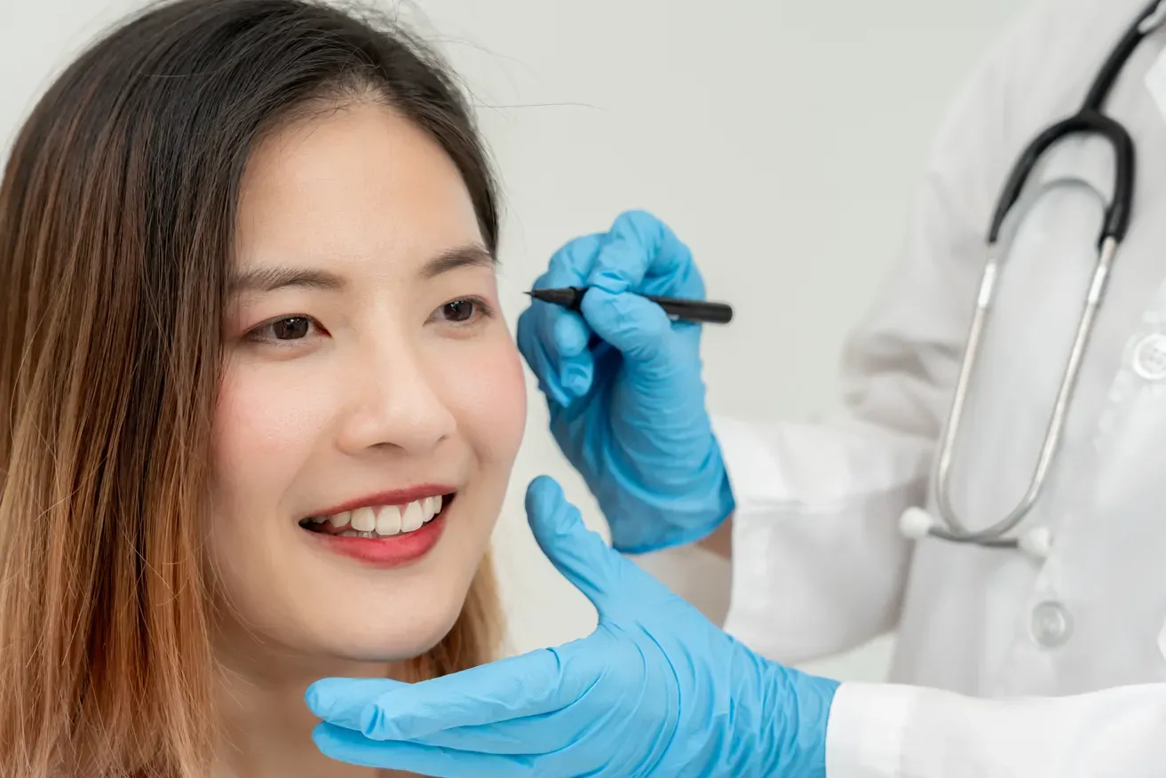 Plastic surgeon examining woman’s eyelids for ptosis correction