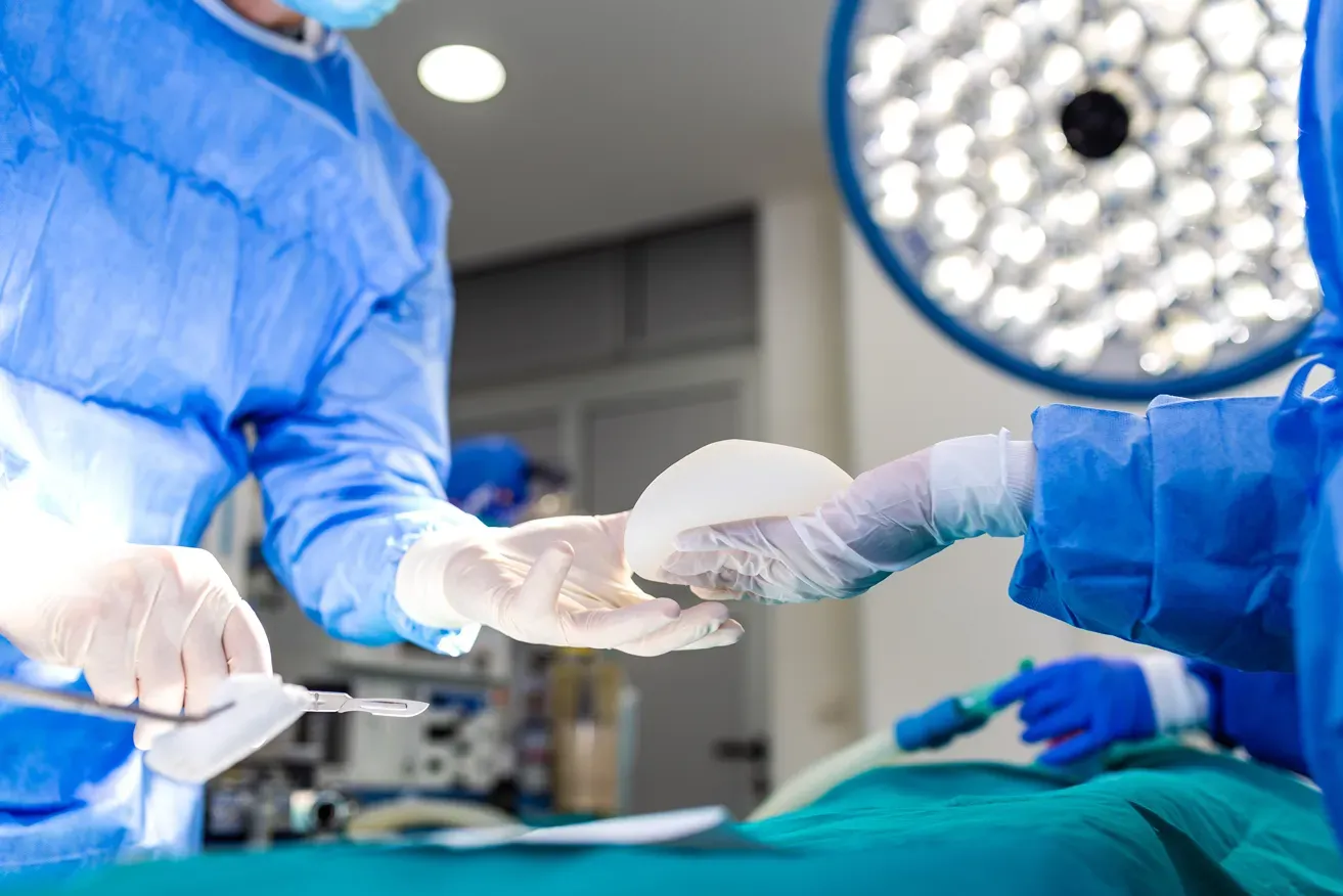 Plastic surgeon performing breast surgery in an operating theatre
